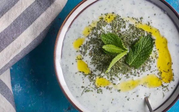 a bowl of Cacik topped with mint and olive oil